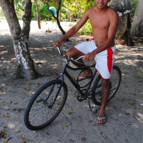 Para transitar pelas comunidades locais, o garoto usa uma bicicleta, como vários jovens da região
